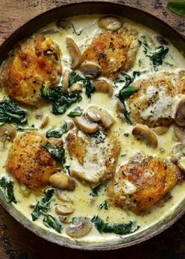 Chicken thighs stewed with mushrooms and spinach in a cream sauce
